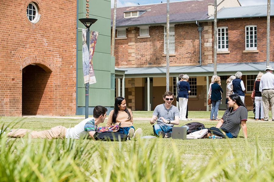 Students sitting in a circle on a campus lawn