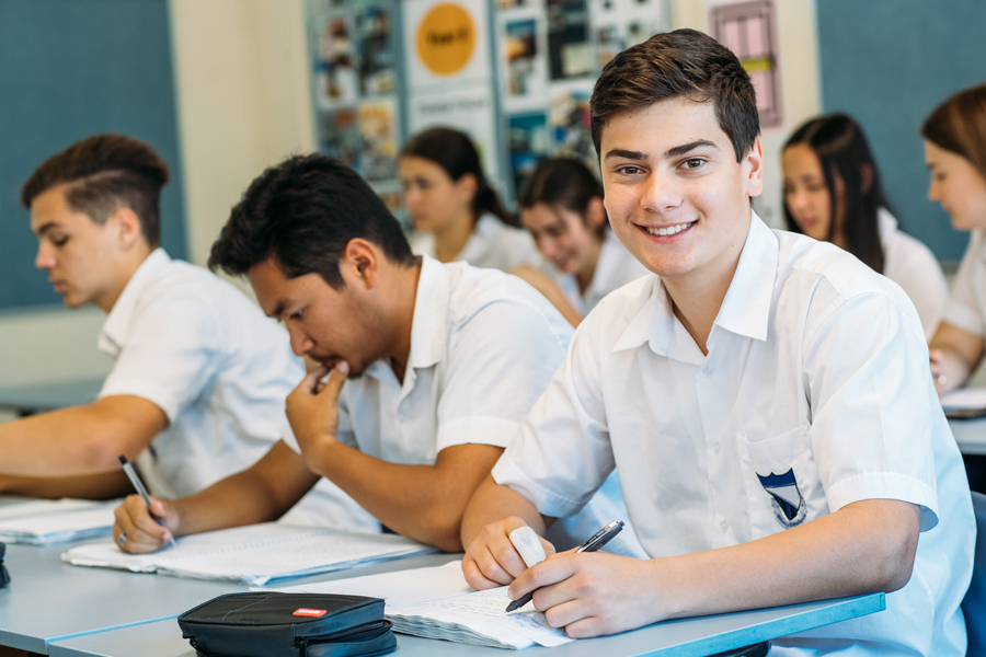 High school student in classroom smiling to camera