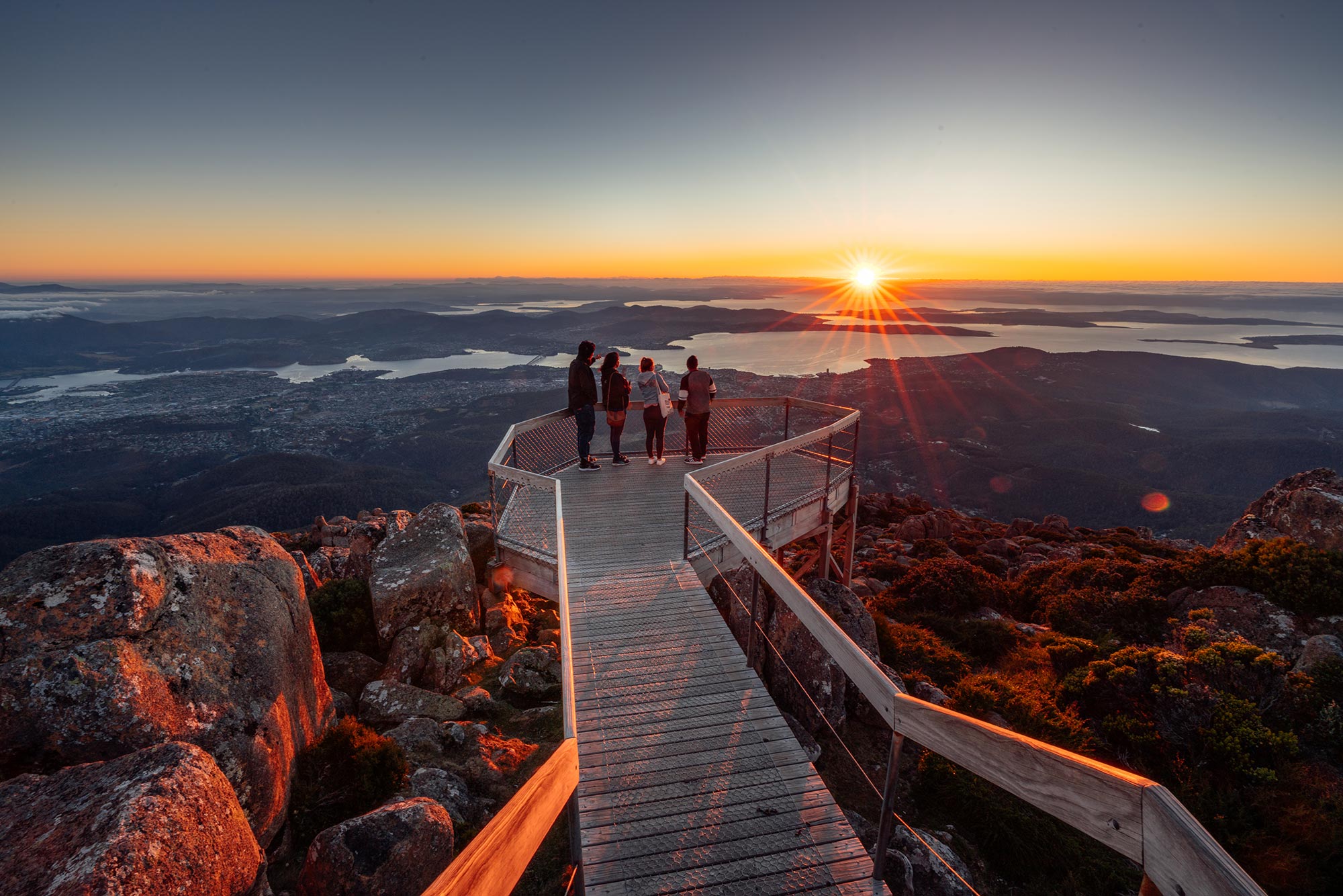 students at a lookout on mount wellington watching the sunrise